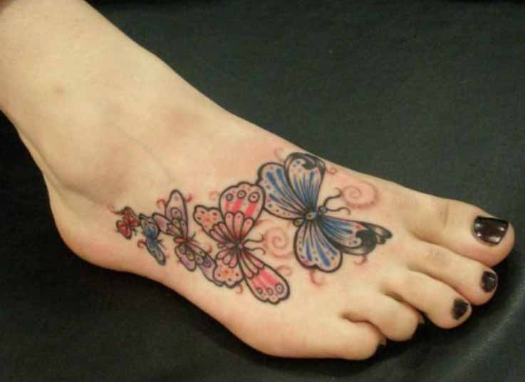 Colorful Flying Butterflies Tattoo On Foot.