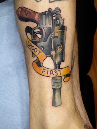 Colorful Star War Gun With Banner Tattoo Design For Leg