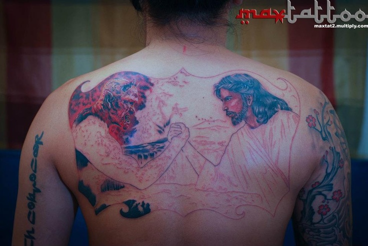 Demon And Jesus Arm Wrestling Tattoo On Man Upper Back