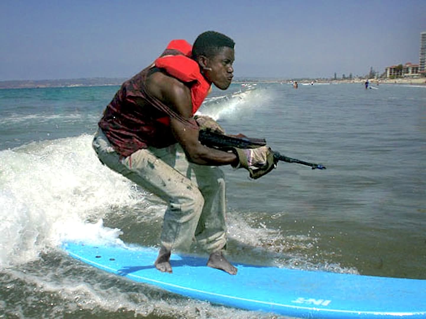 Funny Man With Gun On Surfing Board