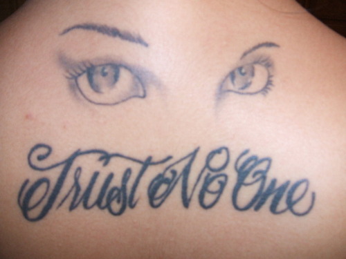 Grey Ink Girl Eyes And Trust No One Tattoo On Upper Back