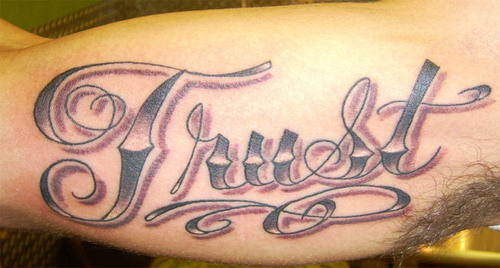 Grey Ink Trust Tattoo On Inner Bicep