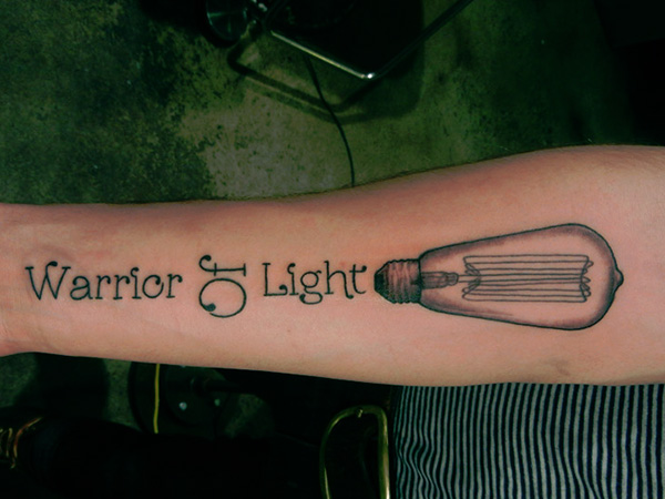 Light Bulb With Warrior Of Light Quote Tattoo On Forearm