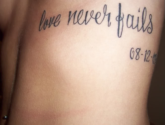 Memorial Love Never Fail Lettering Tattoo Design For Under Breast