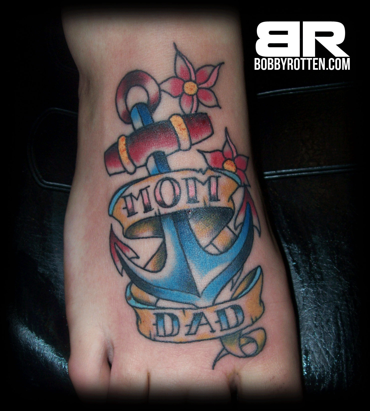 Mom Dad Banner And Color Anchor Tattoo On Right Foot