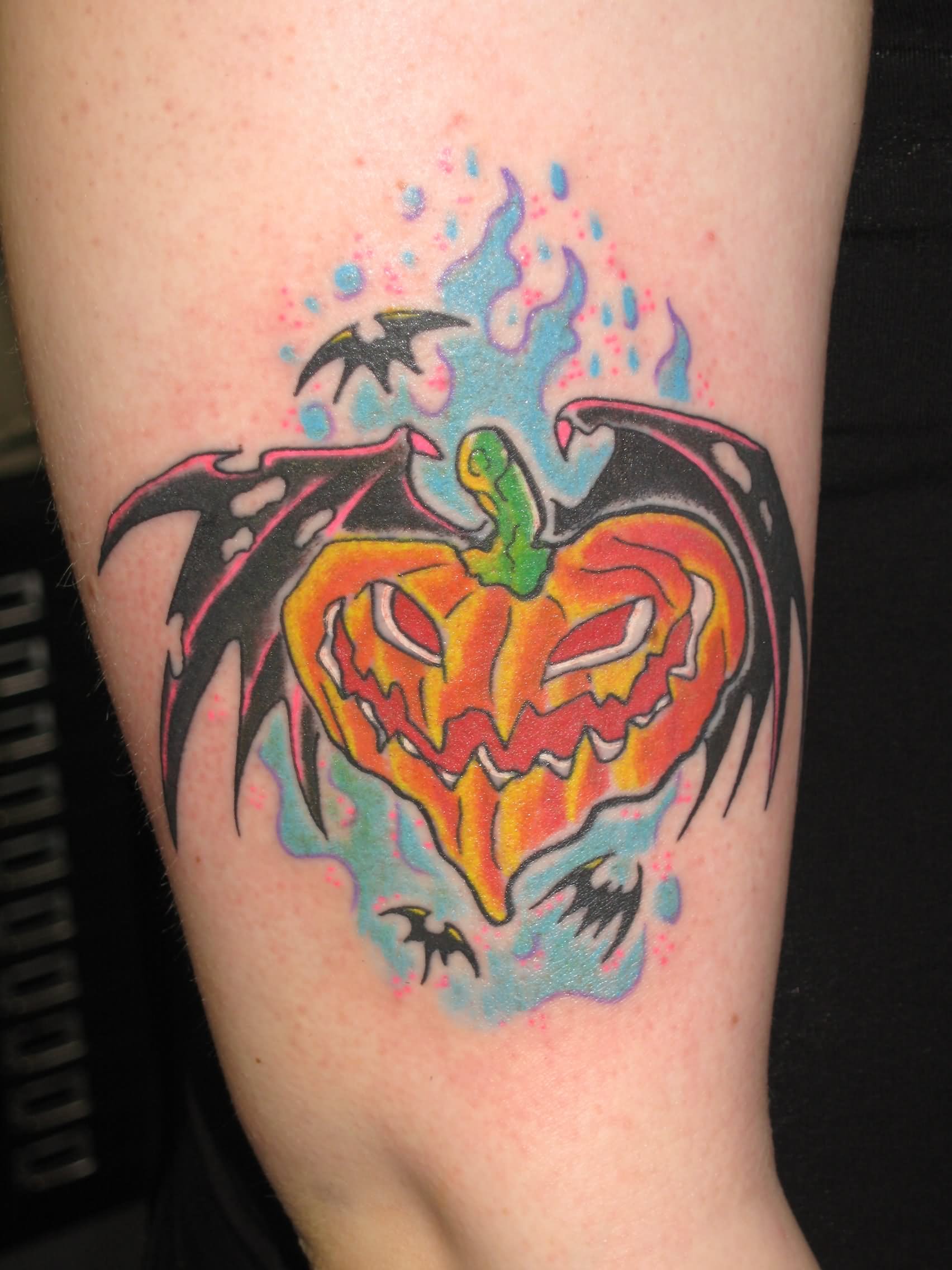 Pumpkin With Bat Wings Tattoo On Bicep