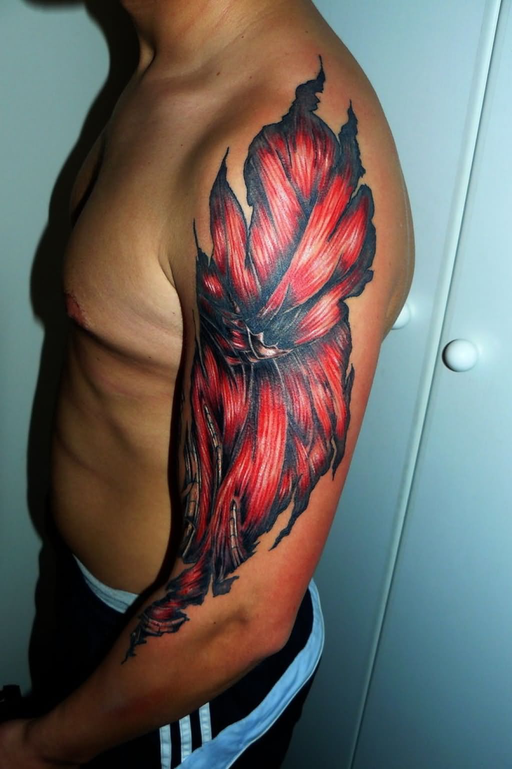 Red And Black Ripped Skin Muscle Tattoo On Man Left Half Sleeve