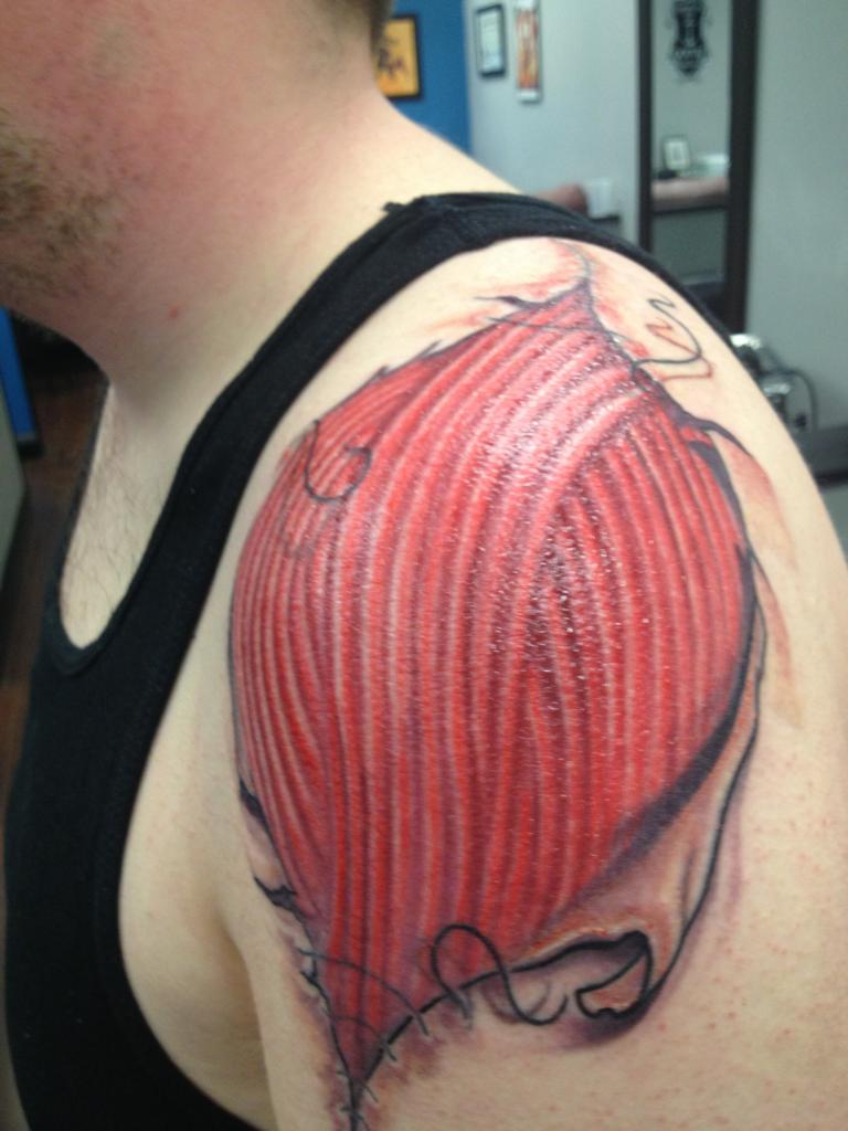 Red Ripped Skin Muscle Tattoo On Man  Left Shoulder