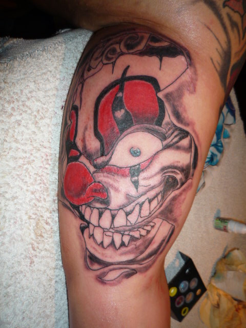 Ripped Skin Clown Head Tattoo Design For Bicep