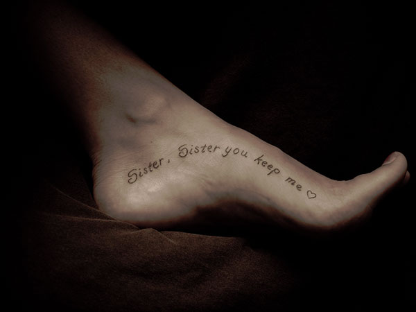 Sister, Sister You Keep Me Lettering Tattoo On Foot