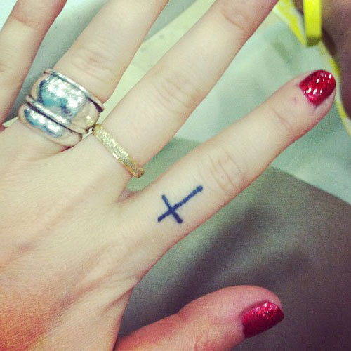 Small Black cross Tattoo On Girl Finger