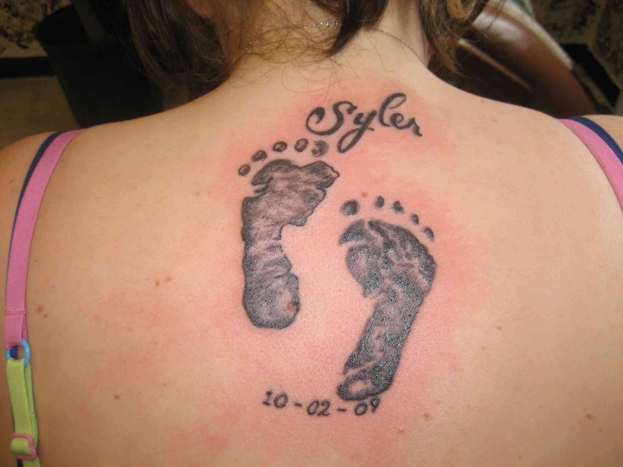 Syler - Memorial Feet Print Tattoo On Girl Upper Back