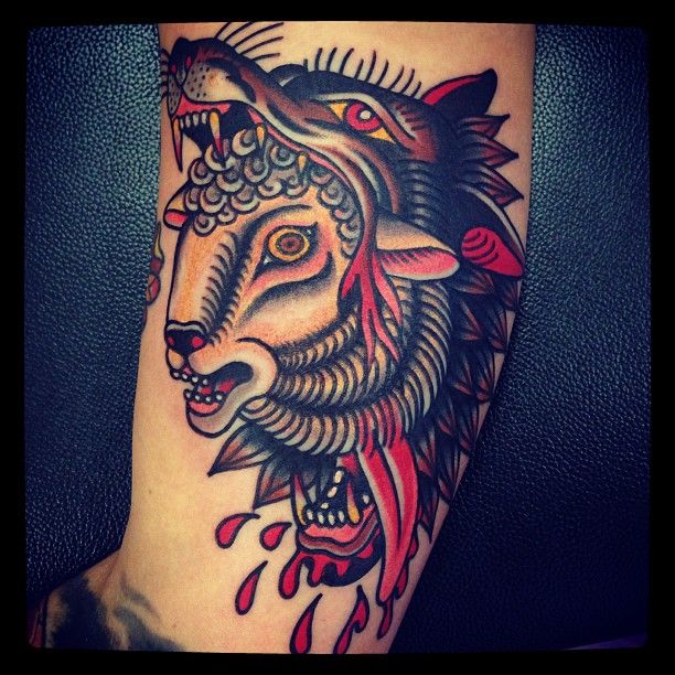Traditional Goat In Wolf Mouth Tattoo On Bicep