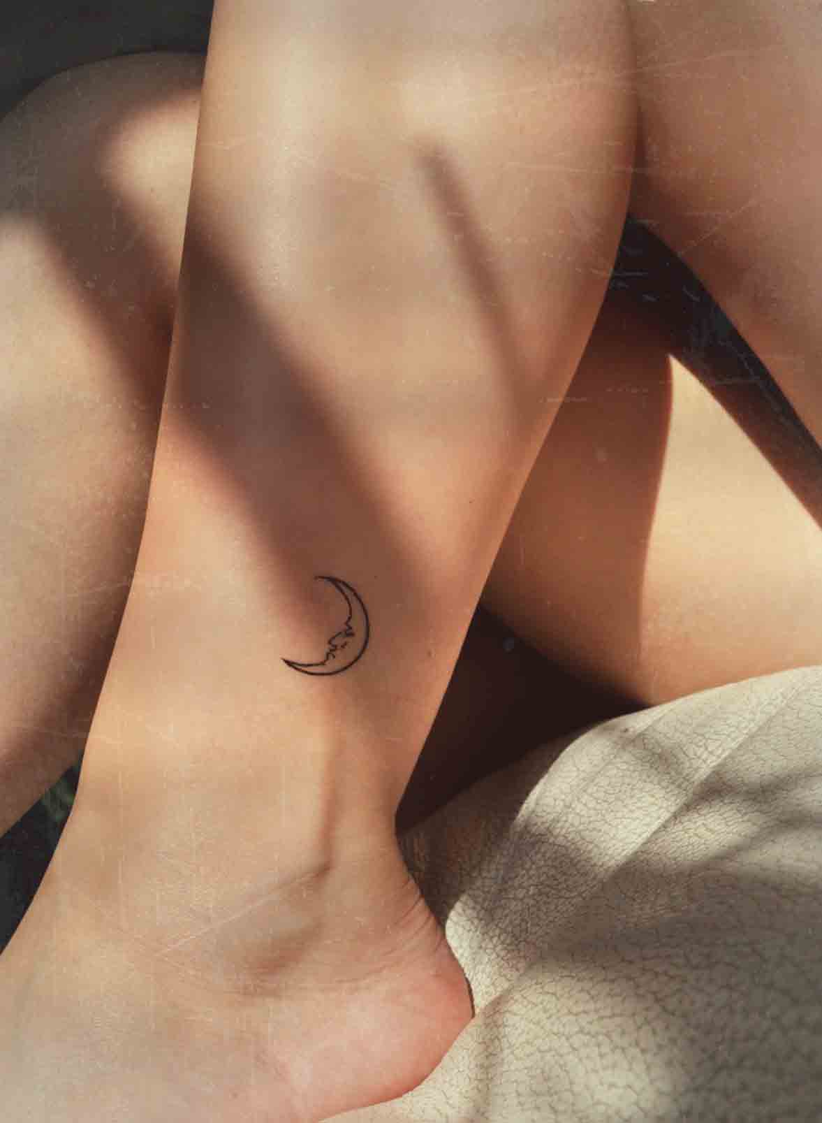 Black Little Outline Half Moon Face Tattoo On Leg