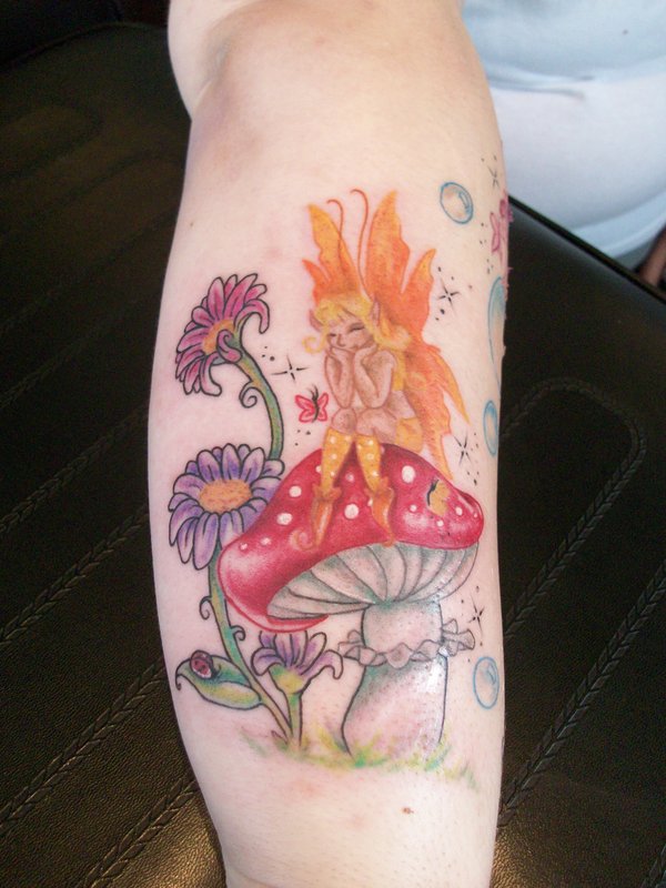 Cute Fairy Sitting On Mushroom Tattoo On Arm
