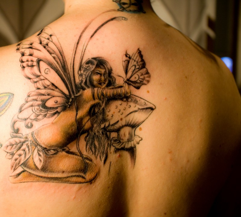 Fairy sitting On Mushroom Tattoo On Back