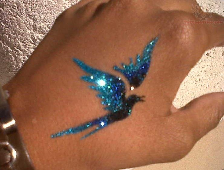 Attractive Glitter Flying Bird Tattoo On Hand