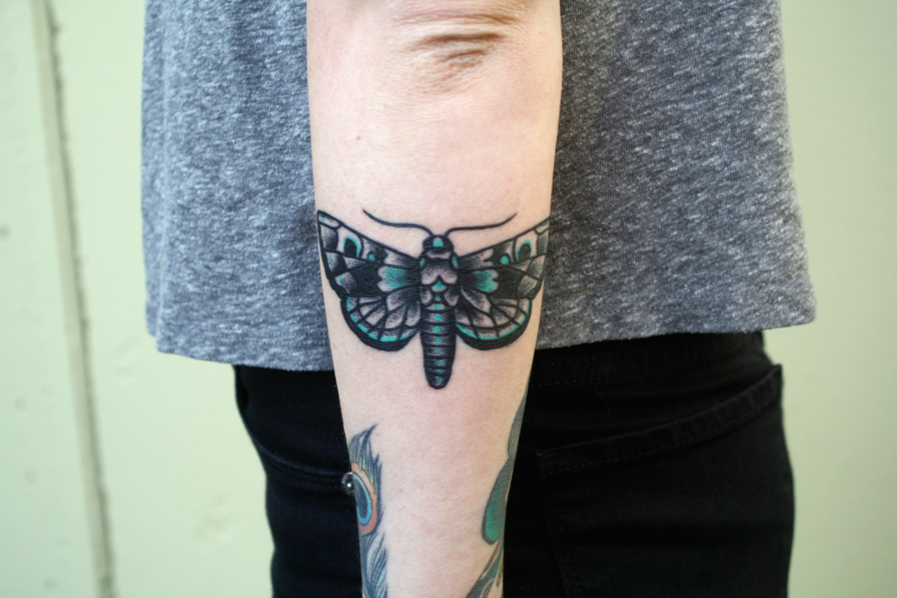 Black And Green Moth Tattoo On Arm