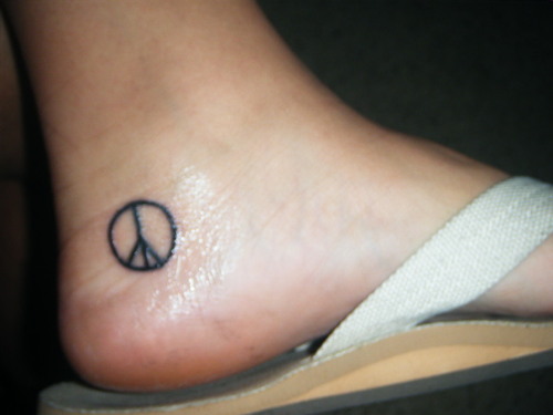 Black Peace Logo Tattoo On Ankle