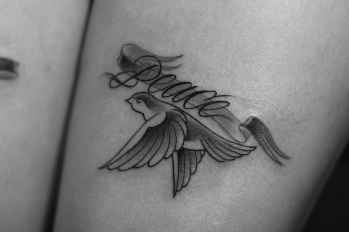 Flying Bird With Peace Banner Tattoo Design