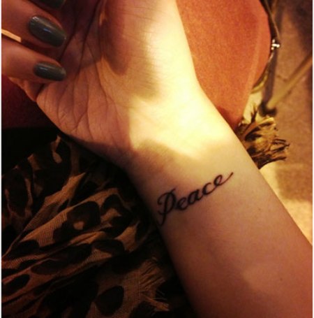 Peace Lettering Tattoo On Girl Wrist