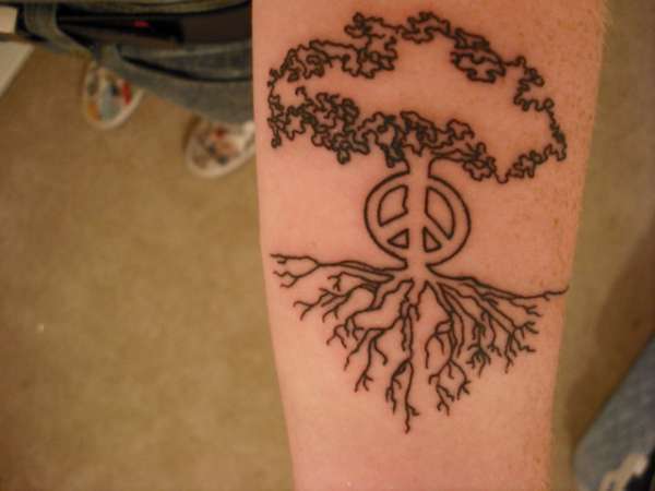 Peace Logo In Tree Tattoo On Forearm