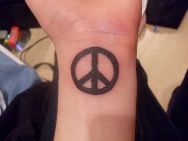 Silhouette Peace Logo Tattoo On Wrist