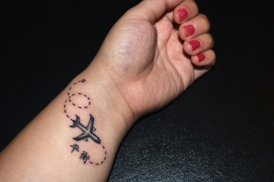Black And Grey Airplane Tattoo On Girl Wrist