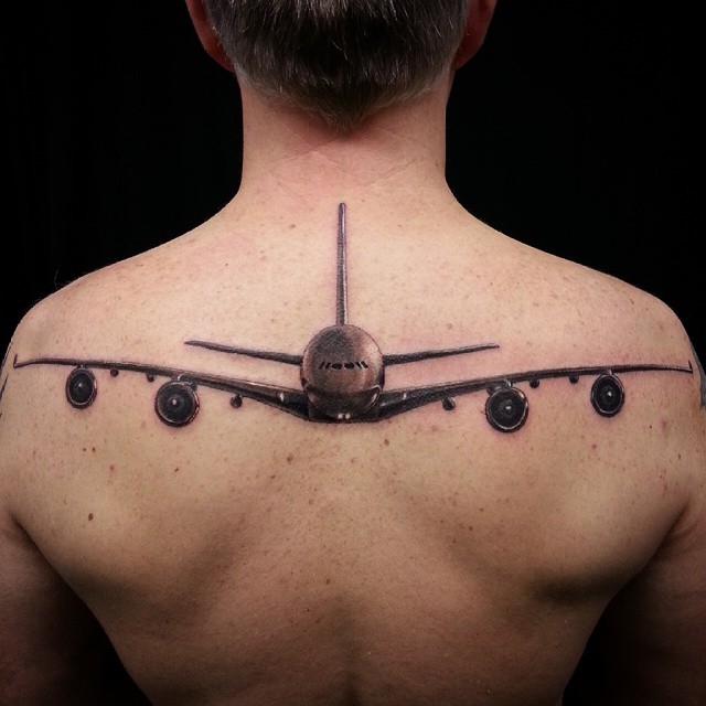 Black And Grey Airplane Tattoo On Man Upper Back