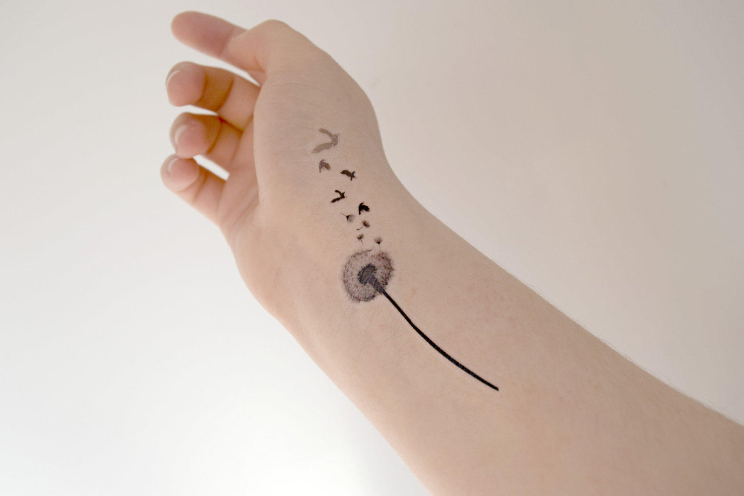 Black Ink Dandelion With Flying Birds Tattoo On Wrist