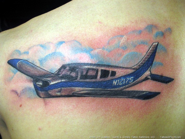 Blue And Black Airplane Tattoo On Left Back Shoulder
