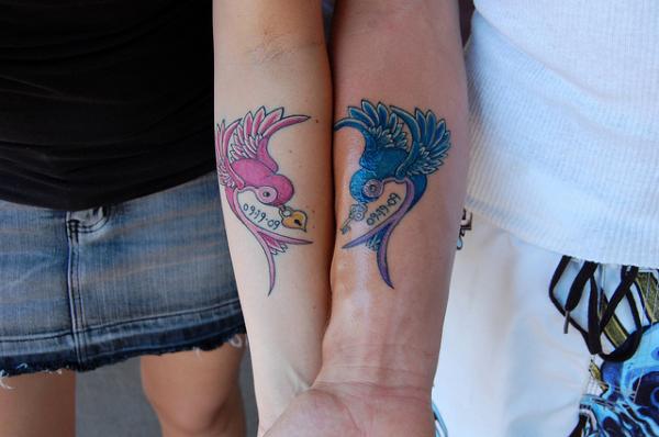 Colorful Bird Tattoo On Couple Forearm