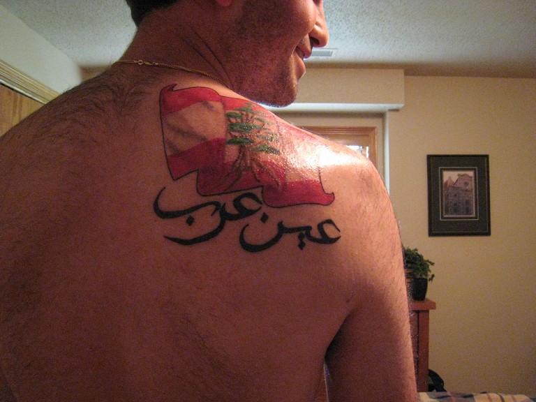 Flag And Arabic Tattoo On Man Right Back Shoulder