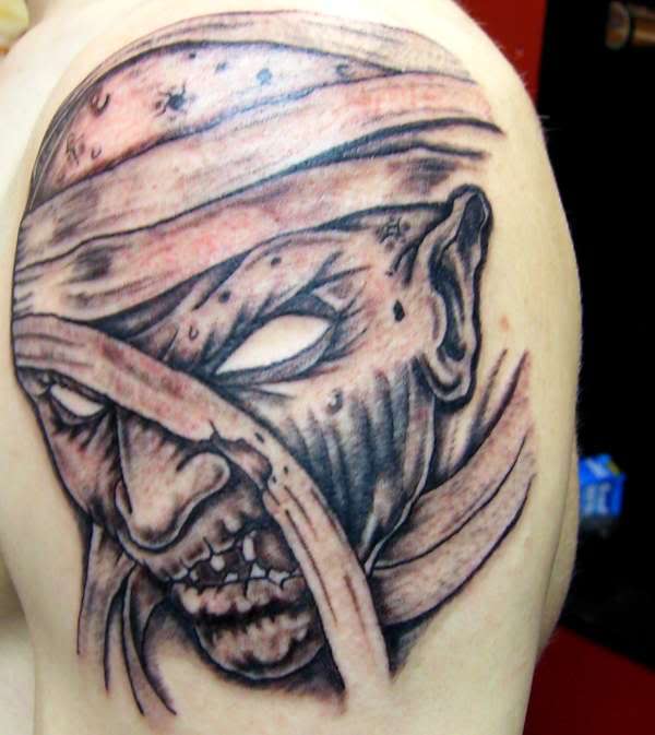 Grey Ink Mummy Head Tattoo On Left Shoulder