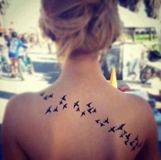 Little Black Flying Birds Tattoo On Girl Upper Back