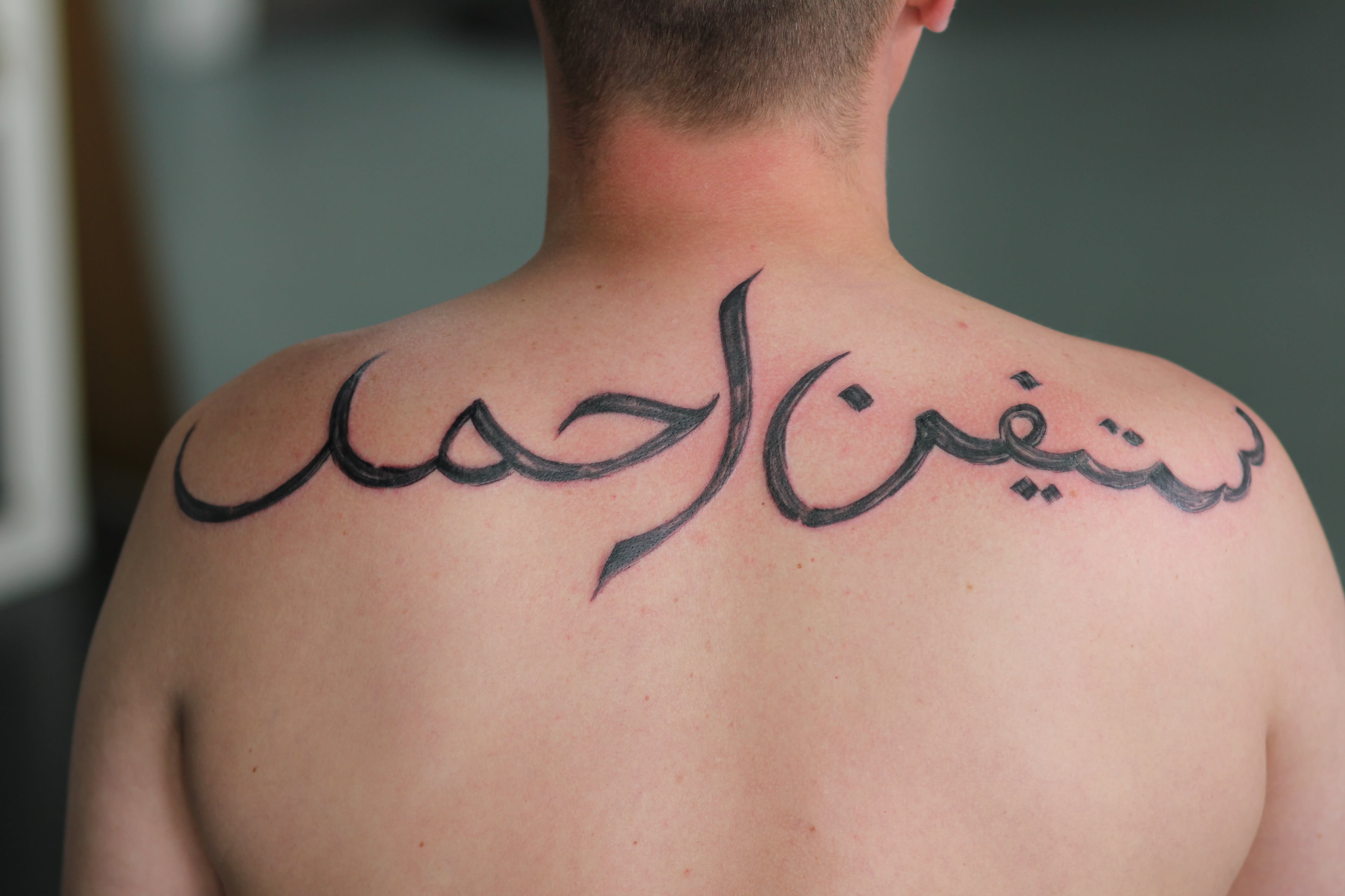 Nice Arabic Tattoo On Man Upper Back