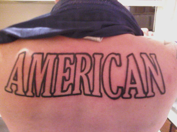 American Lettering Tattoo On Man Upper Back