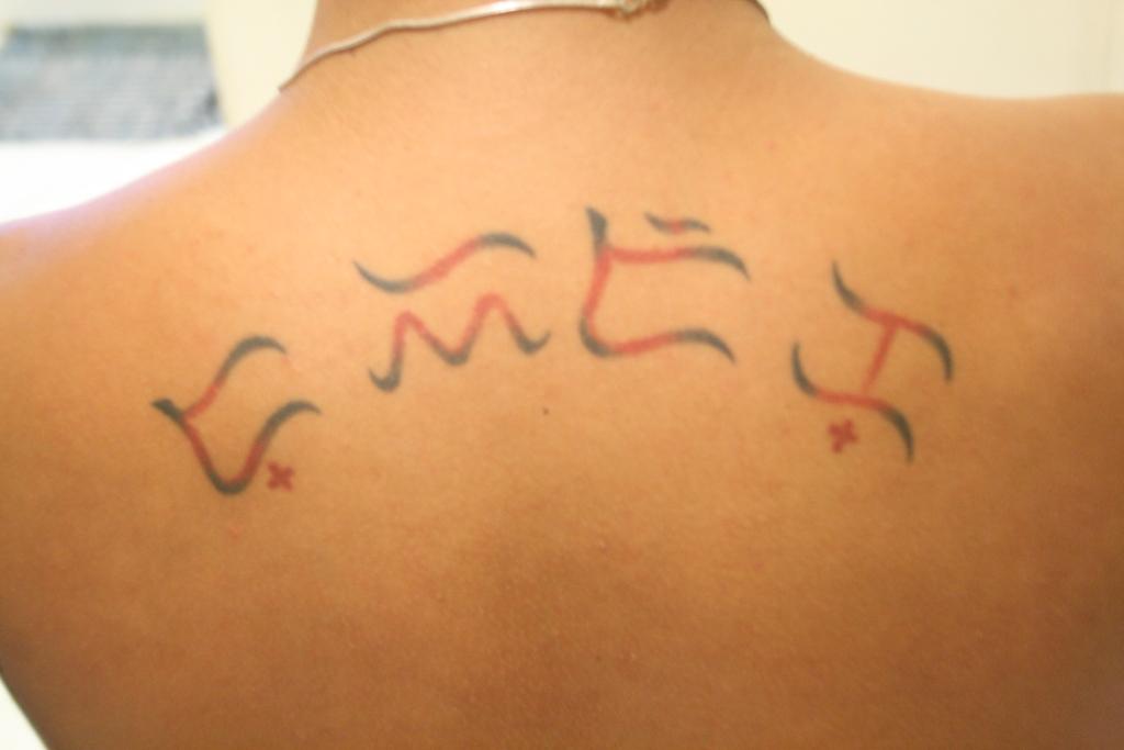 Black And Red Ink Alibata Tattoo On Upper Back