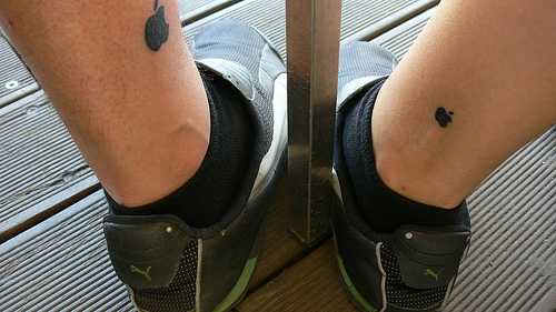 Black Two Apple Logo Tattoo On Both Leg