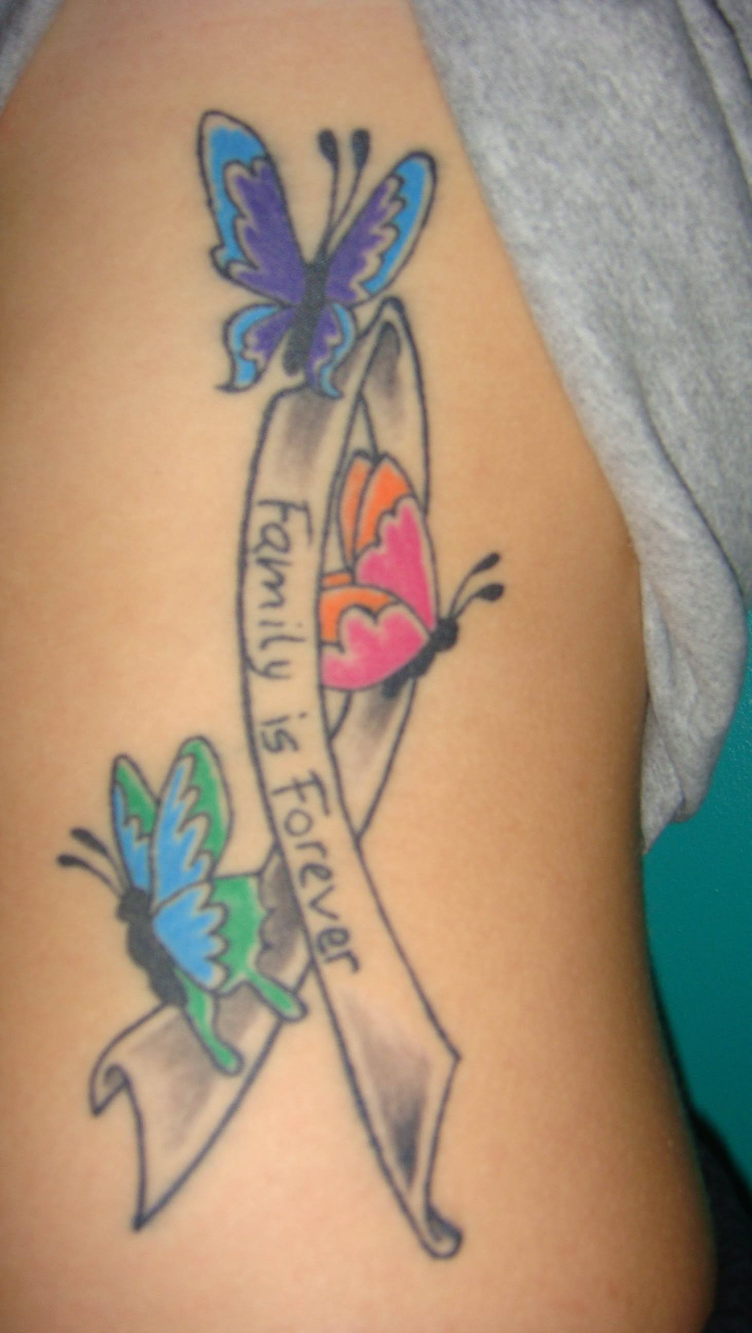 Colorful Butterflies And Family Is Forever Ribbon Tattoo On Side Rib