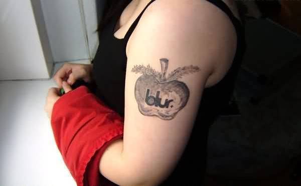 Grey Ink Apple Tattoo On Girl Left Half Sleeve