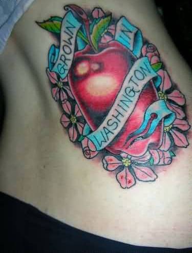 Red Apple With Flowers And Banner Tattoo On Side Rib