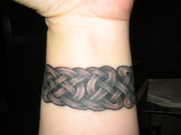 Black Ink Celtic Wristband Tattoo On Wrist