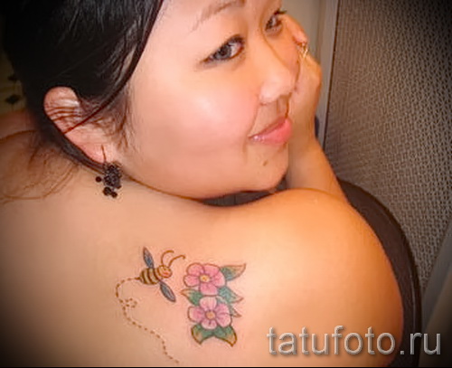 Flying Bee And Flowers Tattoo On Girl Right Back Shoulder