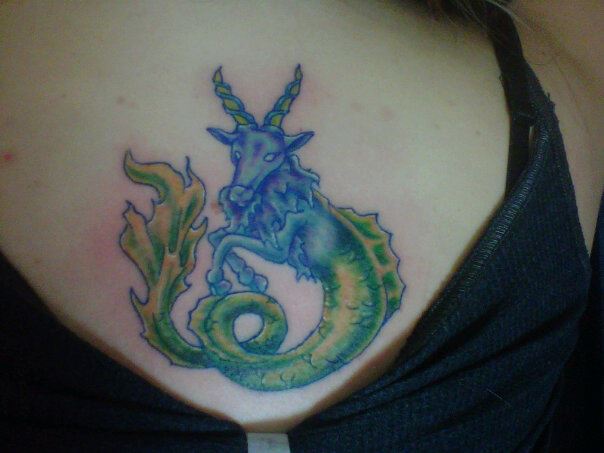 Green Ink Capricorn Tattoo On Girl Back Shoulder