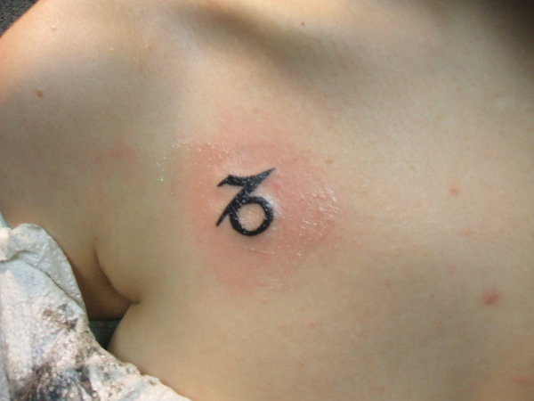Small Capricorn Symbol Tattoo On Collarbone