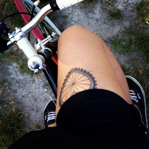 Bike Wheel In Heart Shape Tattoo On Thigh