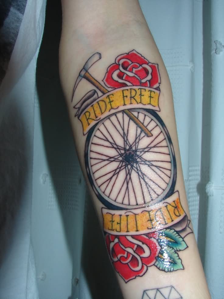 Bike Wheel With Banner And Roses Tattoo On Forearm