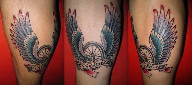 Bike Wheel With Wings And Banner Tattoo On Leg Calf