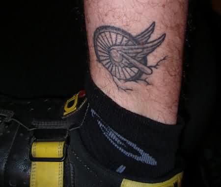 Black And Grey Bike Wheel With Wings Tattoo Design